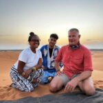 guide in the sahara desert with two tourist while all inclusive morocco from marrakech